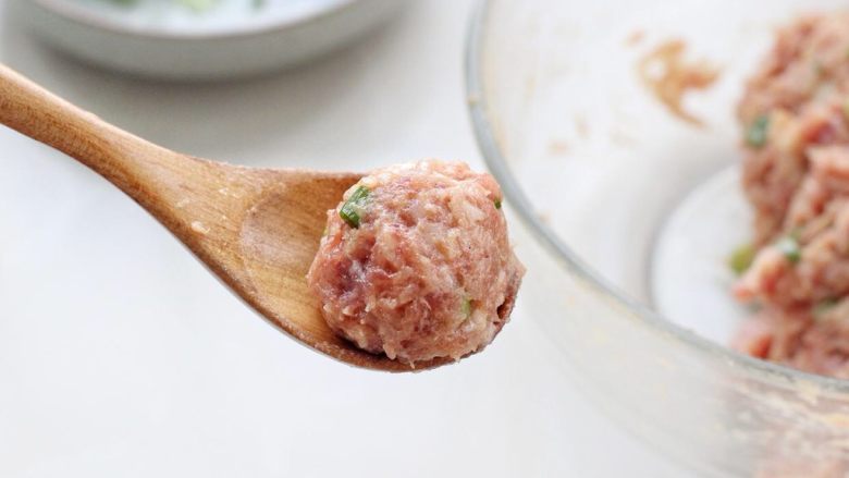 萝卜肉丸汤,待萝卜基本煮熟了,用勺子挖取适量肉糜团成丸子状,一个一个地下入锅中。