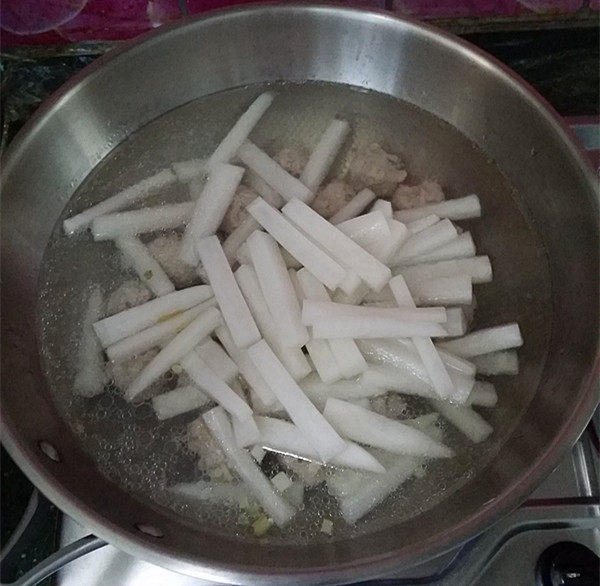萝卜肉丸汤,接着放入切好的萝卜条,大火煮开