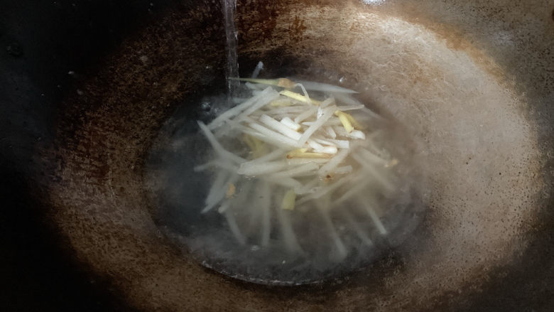 萝卜肉丸汤,待萝卜丝略微变软,加入适量清水。