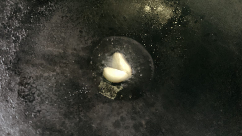 雪菜炒冬笋,锅烧热油,加入蒜瓣爆炒出香味