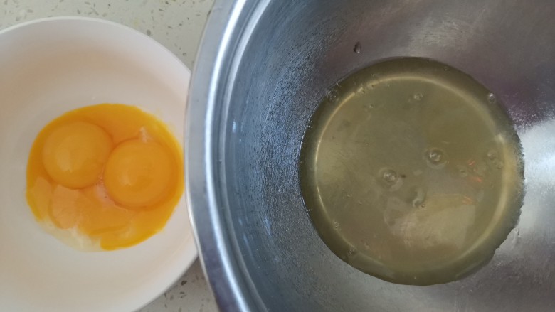 酸奶芝士蛋糕,准备两个干净无油无水的盆,分离蛋清和蛋黄,蛋白里不能掉入蛋黄,否则蛋白打不起来,分离好的蛋白放冰箱冷藏备用