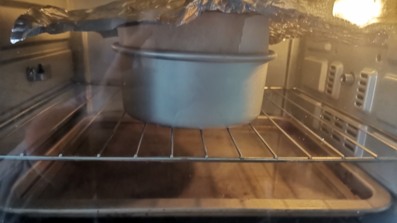酸奶芝士蛋糕,送入预热好的烤箱,上下火160度烤60~70分钟,水浴法烘烤,蛋糕放中层烤网上,烤盘里加入3厘米的水放下层,蛋糕上色后盖锡纸