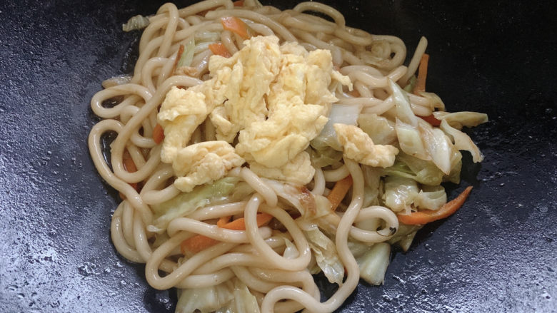 鸡蛋炒乌冬面,再加适量鸡蛋块,大火快炒15s出锅。