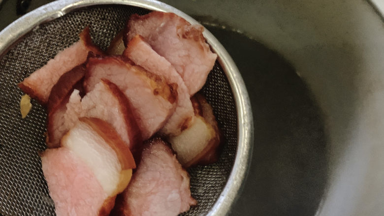 腊肉炒白菜,腊肉入热水中,汆烫洗净一下。