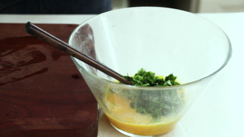 芹菜叶炒鸡蛋,搅拌均匀,把挤干并切碎的叶子加入鸡蛋里搅拌
