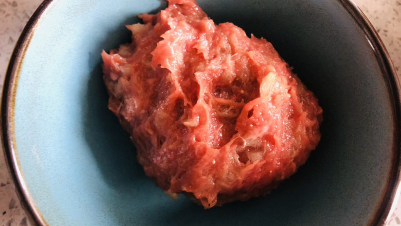 宝宝辅食,香煎肉饼,用手抓匀,来回摔打肉泥,使肉变得更加有弹性。