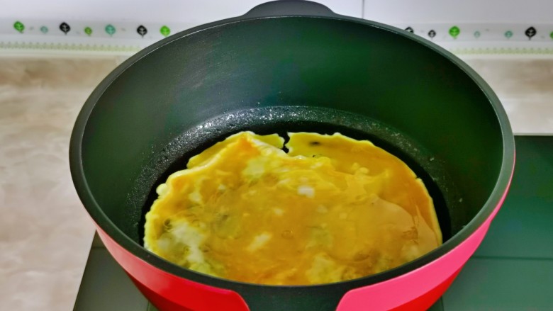 鸡蛋炒乌冬面,起油锅倒入蛋液,小火煎至凝固。