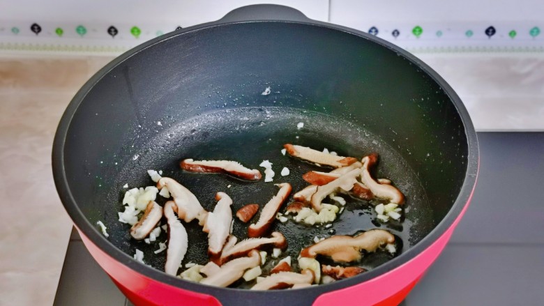 鸡蛋炒乌冬面,另起油锅加入蒜末炒香,再加入香菇煸炒。