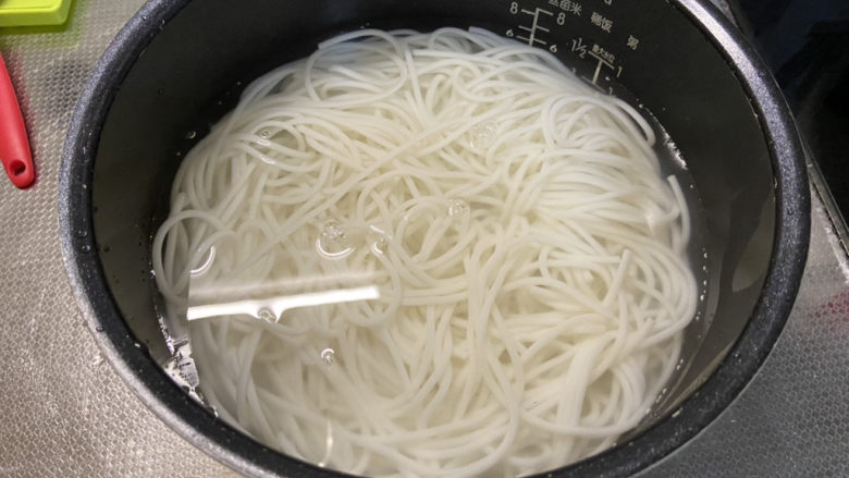 三鲜米线➕牛肉丸鹌鹑蛋番茄三鲜米线,这时米线也泡好了,倒入泡米线的水,用清水淘洗两三次,清水浸泡备用