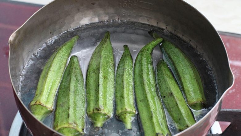 秋葵炒鸡蛋,锅中烧开水,加入一茶匙食用油和少许盐,再放入秋葵焯烫约一、两分钟至颜色变深捞出。