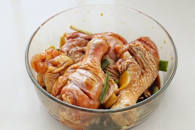 电饭锅焖鸡腿,戴一次性手套抓拌揉搓,给鸡腿来个"全身按摩"后覆盖保鲜膜腌制一小时左右,中途翻拌两次使之腌制的更均匀。