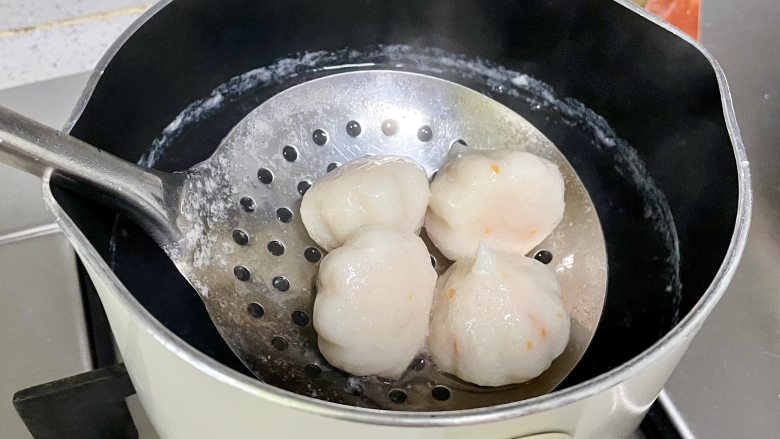 蟹籽包田园蔬菜三明治,锅里烧开水,下蟹籽包煮熟后捞出,沥干水。