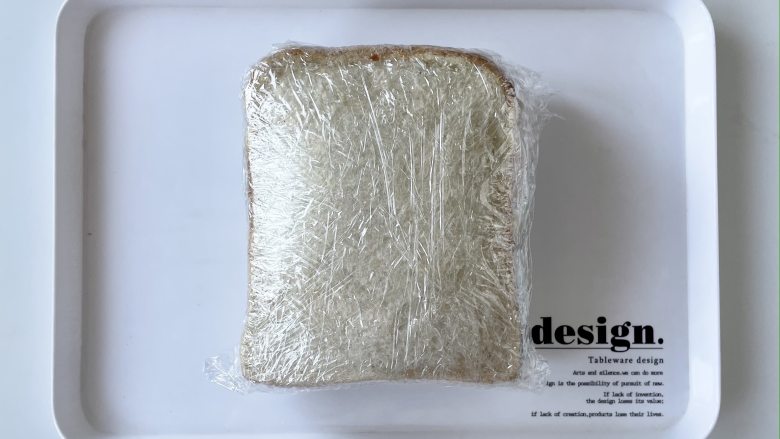 蟹籽包田园蔬菜三明治,把叠好的三明治压好,用保鲜膜裹紧,可以多裹几层。