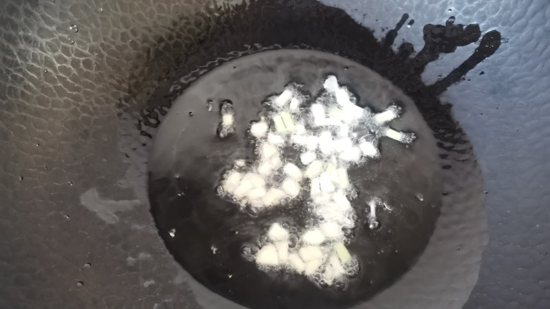 鱿鱼炒年糕,热锅倒入油,放入葱蒜末爆香
