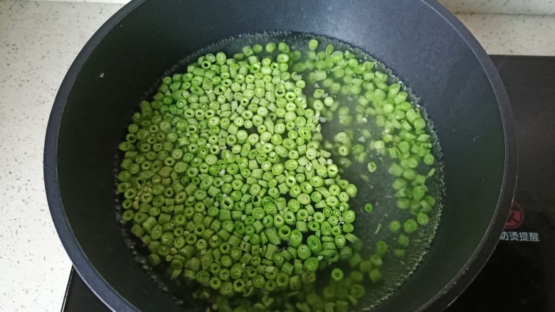 肉末豇豆,锅里水开加一点点盐,然后放缸豆焯水一分钟捞出。