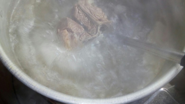 羊肉火锅,羊排放入沸腾的高汤中炖。