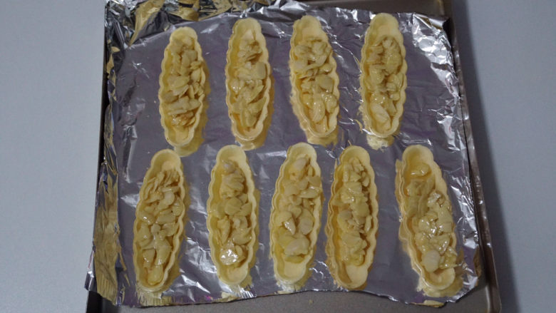 特色小甜品--网红🔥焦糖杏仁糯米船,放入糯米船中,烤箱150度预热、把做好的糯米船放入烤箱中,烘烤15至18分钟即可。