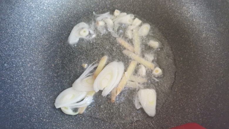 鱿鱼炒年糕,另起锅烧油,下入葱姜蒜爆香