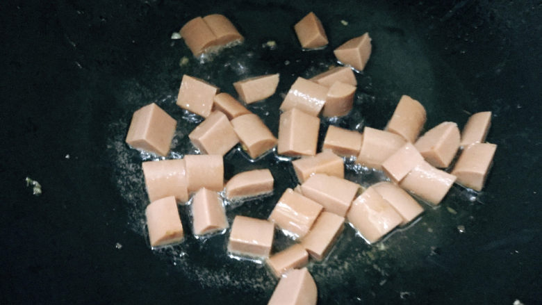 什锦玉米粒,先放入火腿肠,炒至微焦