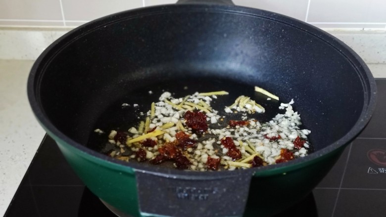 电饭锅焖鸡腿,热锅凉油放入葱姜末,干辣椒段爆香。