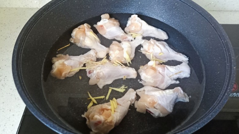 电饭锅焖鸡腿,鸡腿冷水放入锅里,加上生姜丝去腥。