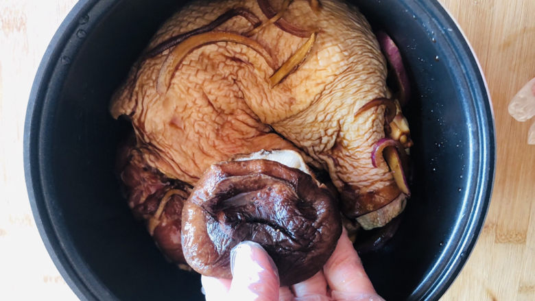 电饭锅焖鸡腿,取出腌好的鸡腿放入电饭锅,鸡皮一面朝下方便上色,放入提前泡好的干<a style='color:red;display:inline-block;' href='/shicai/ 230'>香菇</a>。
洋葱、姜丝、蒜瓣及汤汁一起倒入电饭锅。