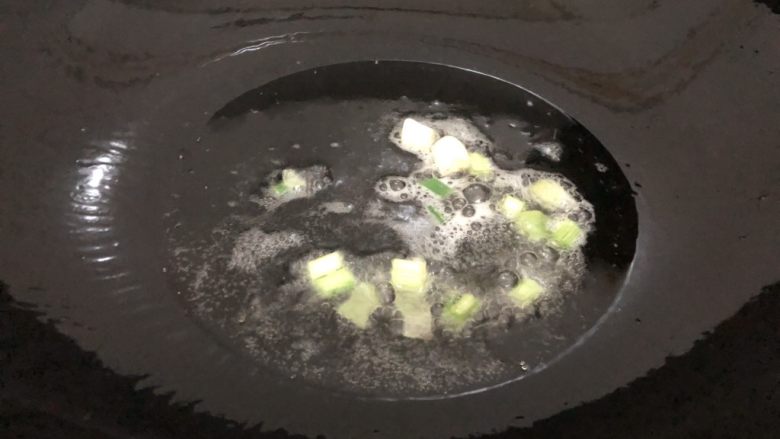 萝卜干炒肉,起锅下油,下葱白爆一下
