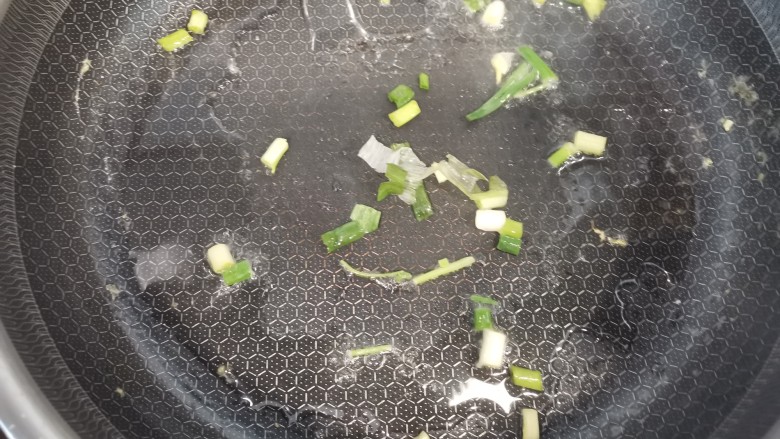 什锦炒饼,锅中放油,加入小葱炒香
