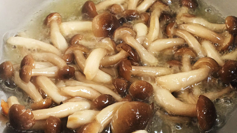 三鲜日本豆腐,放入鲜味菇滑炒至断生,捞出。