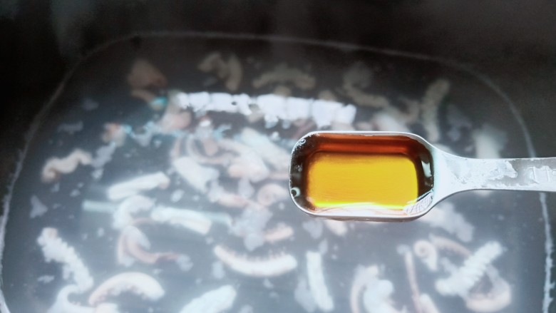 鱿鱼炒年糕,锅里水开下鱿鱼焯水,加料酒两勺。