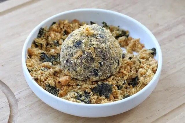 紫米饭团,打开保鲜膜把饭团放到肉松中滚一滚,使饭团均匀的裹满肉松。