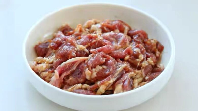 儿菜炒肉片,带一次性手套将肉片和调味料混合抓拌均匀,放置一旁腌制十五分钟。