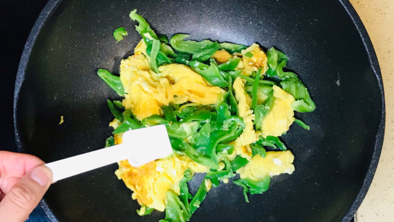 尖椒炒鸡蛋,翻炒至尖椒恹恹后,撒入盐调味