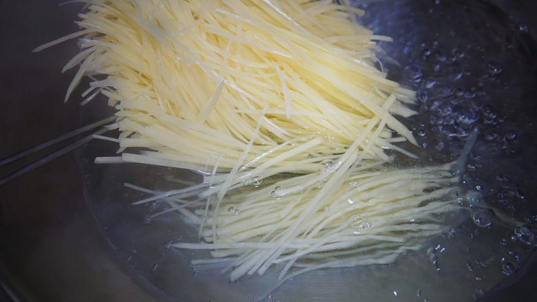 青椒炒土豆丝,水开后加盐,土豆丝焯烫半分钟,捞出过冷水,这样可以进一步去掉多余淀粉,使得土豆丝口感更加脆爽