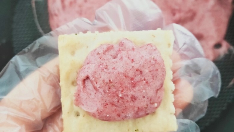 草莓味牛扎饼干,取一块苏打饼干,再放上少许做好的草莓牛轧