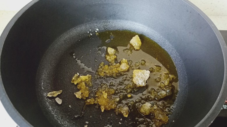蒜香鸡腿,锅稍微热加少许的食用油(锅温度太高容易发糊)加入冰糖开中小火炒糖色。