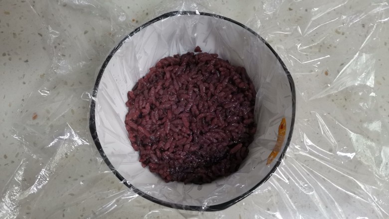 紫米饭团,取一个小碗,铺上保鲜膜,舀一勺紫米饭压实