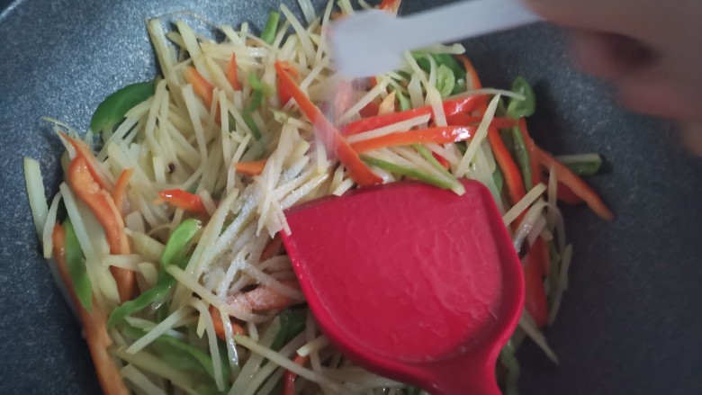 青椒炒土豆丝,加入适量的盐,翻炒均匀