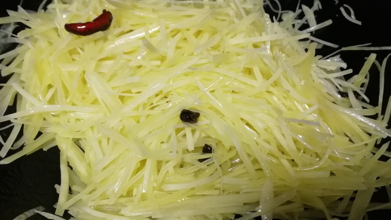 青椒炒土豆丝,油热放入土豆丝,急火翻炒均匀。