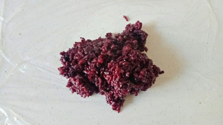 紫米饭团,铺一层保鲜膜,舀适量米饭放在保鲜膜上