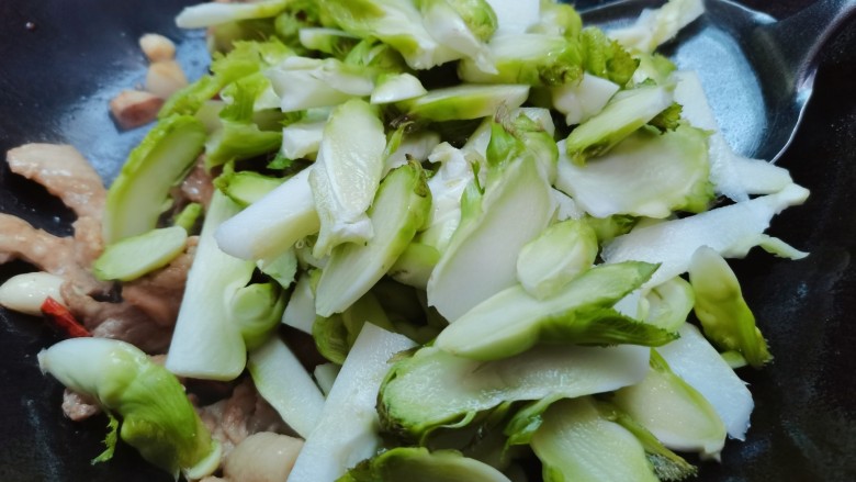 儿菜炒肉片,接着倒入儿菜,翻炒至一会儿