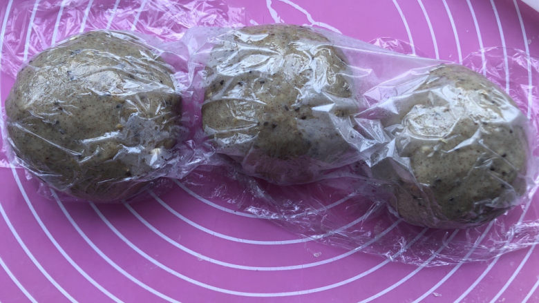 杂粮吐司,平均分割成三个小团,盖保鲜膜醒发15分钟。