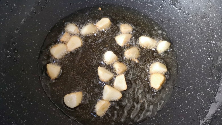蒜香鸡腿,炒锅内倒适量的食用油烧热,下入大蒜中火炸至蒜香味飘出。
