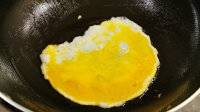 尖椒炒鸡蛋,锅中留下底油继续加热,倒入鸡蛋液。
