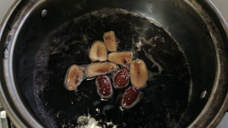 红枣黑米粥,带米汤逐步浓稠，加入红枣继续煮，并不断搅拌，期间尝试一下黑米的软烂程度。