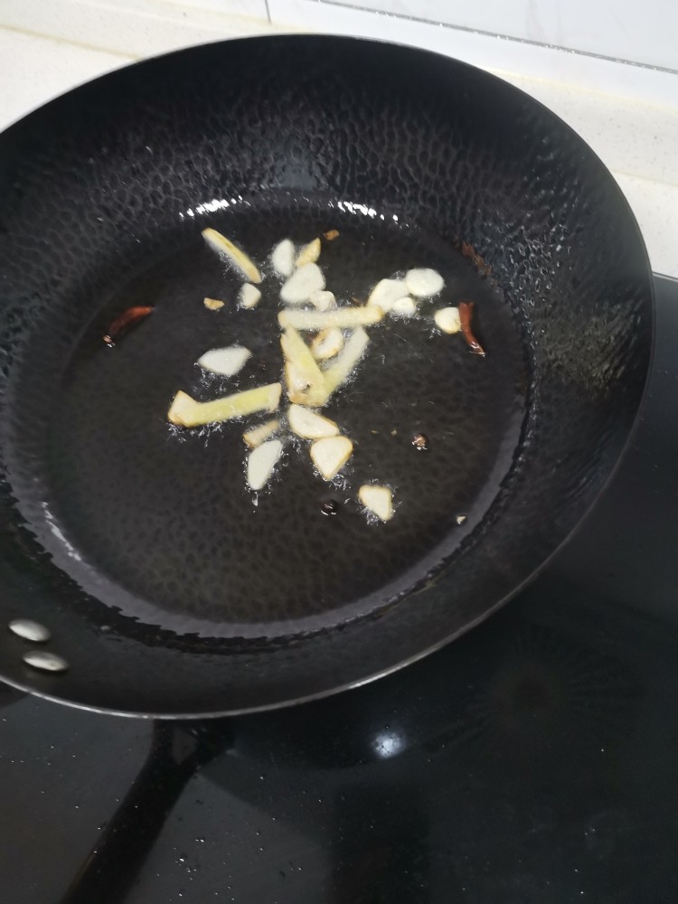 爆炒鱿鱼花,起锅烧油,干辣椒,葱姜蒜炝锅。