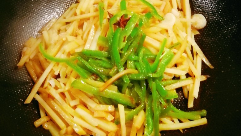 青椒炒土豆丝,放入青椒翻炒均匀,淋入<a style='color:red;display:inline-block;' href='/shicai/ 3738'>芝麻油</a>关火出锅。