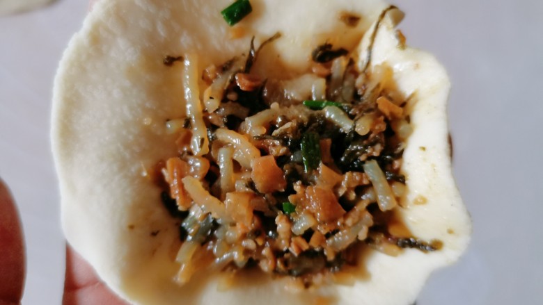 梅干菜肉包,再把它擀成外面薄中间厚的面皮,再放入馅料