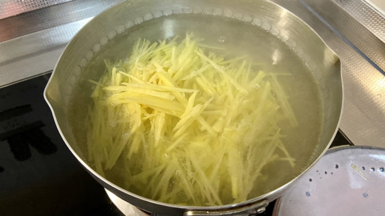 青椒炒土豆丝,坐锅烧水,水开,下土豆丝,中火煮十来秒,