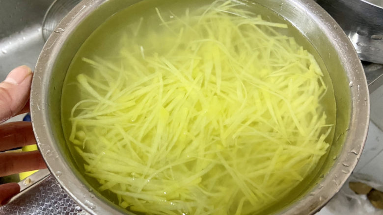 青椒炒土豆丝,捞出过几遍凉水,洗掉多余淀粉,让土豆丝更脆